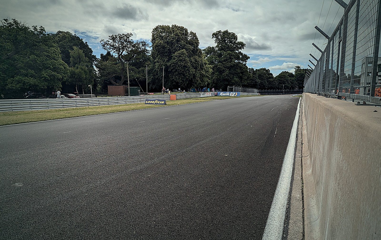 Period racing motorcycles in a circuit paddock at dusk